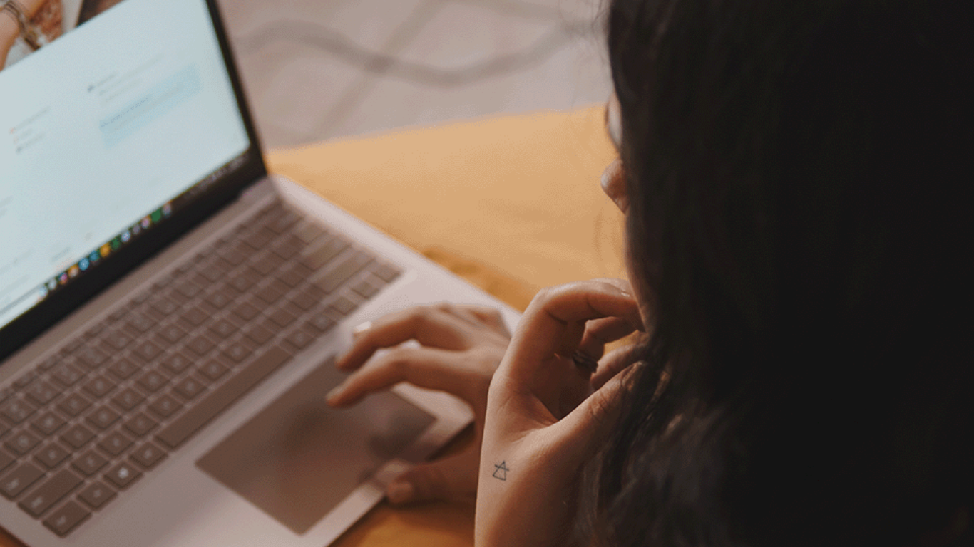 Woman sitting with a laptop, learning AI-powered business strategies through a self-paced ChatGPT mastery course.