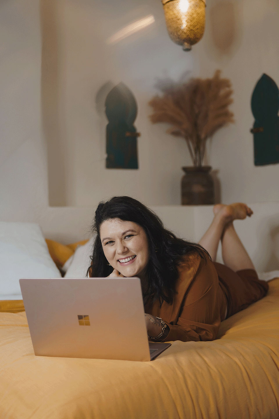 Ashley of Rebirth Your Biz working at her laptop, soul-led business coach and Podia web designer