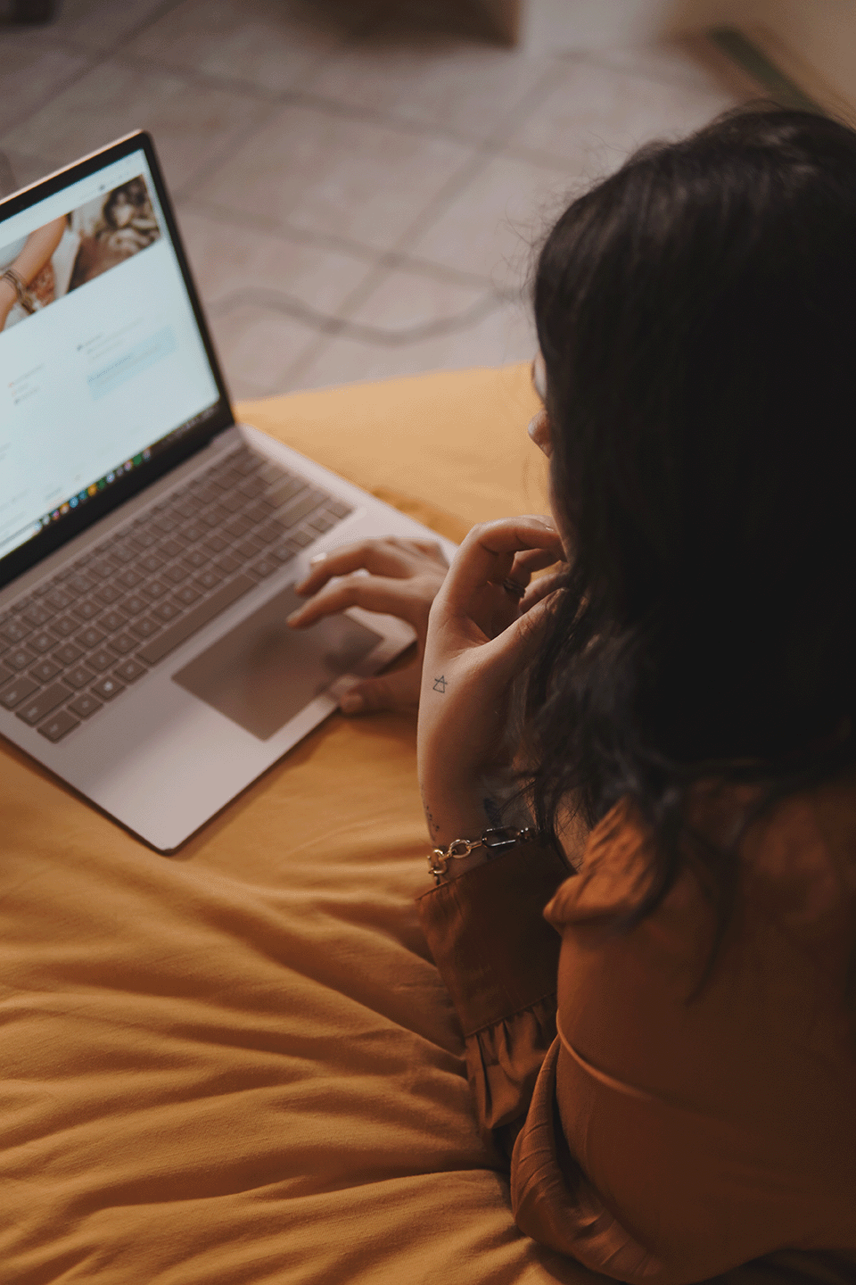 Ashley of Rebirth Your Biz working at her laptop, soul-led business coach and Podia web designer